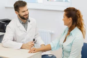Woman visiting dermatologist with referral